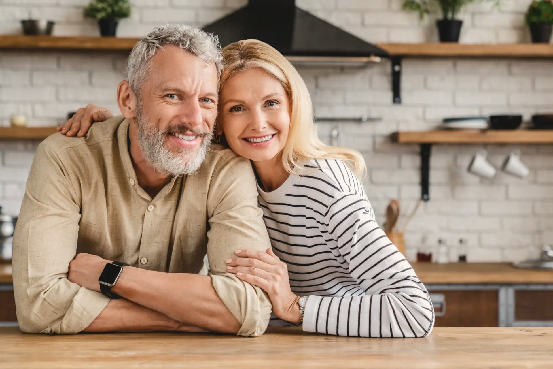Smiling mature couple embracing in a kitchen