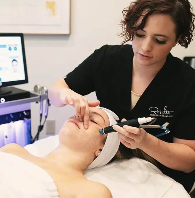 Esthetician performing a facial treatment on a client at Results Medical Aesthetics