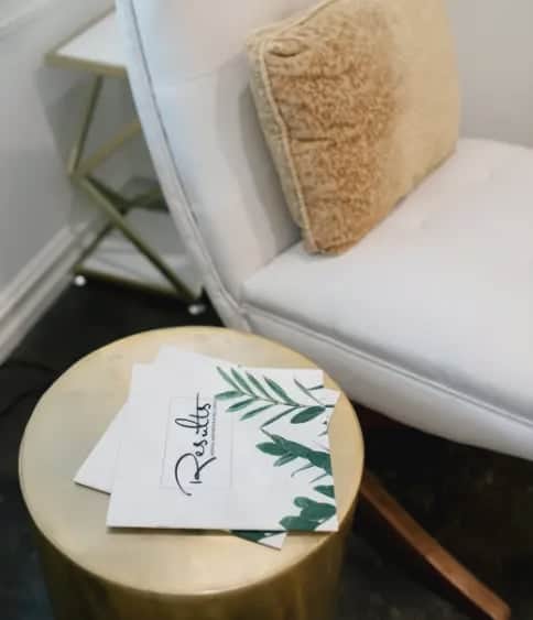 Clinic waiting area with a white chair and Results branded brochures