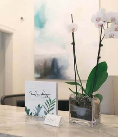 Marble reception counter with an orchid and Results Medical Aesthetics brochure