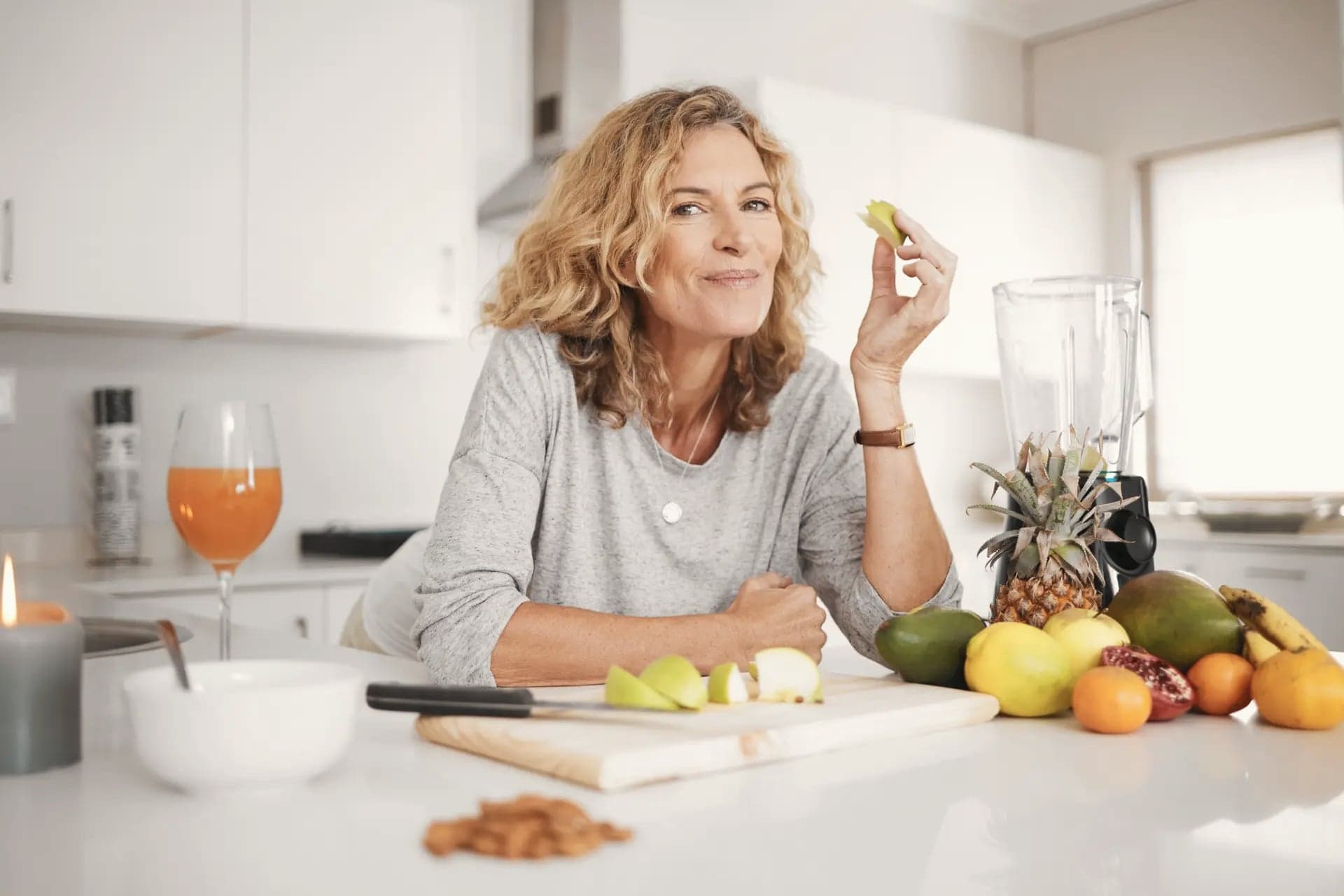 Mature woman preparing fresh fruit in a bright kitchen